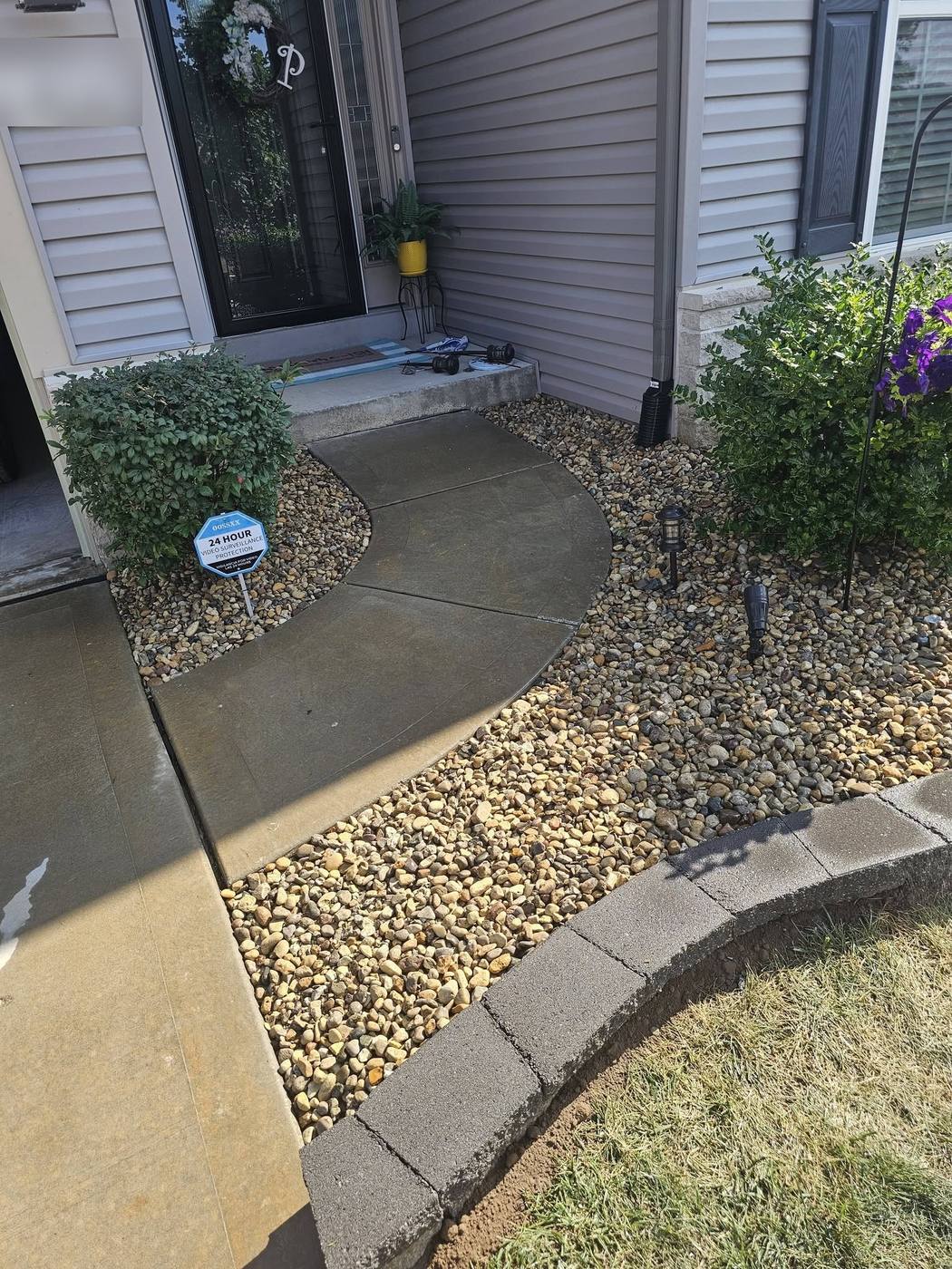Rock bed and block edging along a front walk