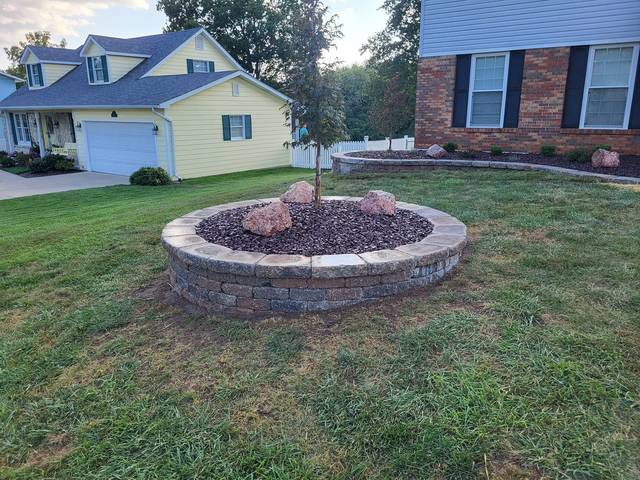 Round raised bed with a young tree in the front lawn