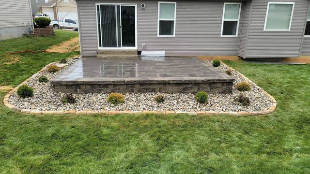 Raised patio wrapped in a planted rock bed