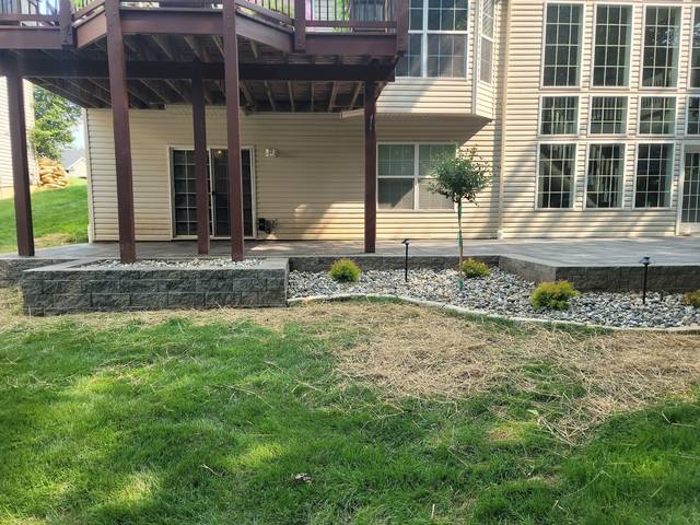Patio under the deck with a low block wall and path lights