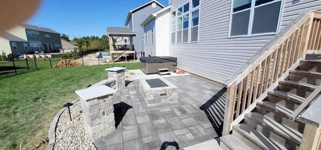 Fire pit and pillars on a new patio beside the deck stairs