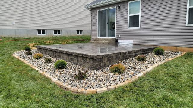 Raised patio with a block face and a rock border